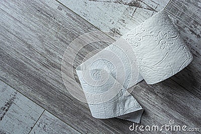 White toilet paper on wooden floor top view close up Stock Photo