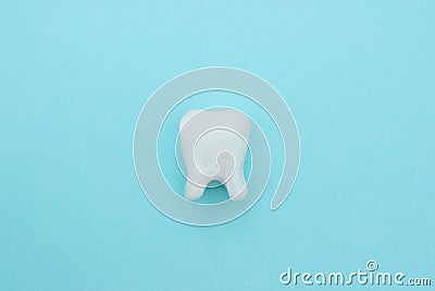 White tooth on blue background with copy space, close-up Stock Photo