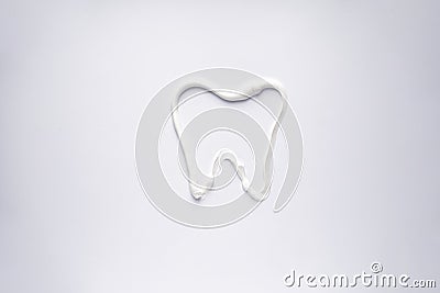 White toothpaste in the form of a tooth on a white background, close-up Stock Photo