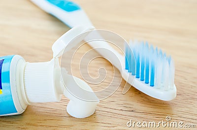 White toothpaste spill out a tube of toothpaste and toothbrush. Stock Photo