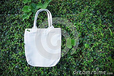 White tote canvas fabric eco bag cloth shopping sack on green leaf nature background Stock Photo