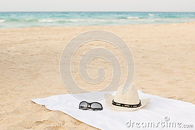 White towel on the beach with sunglasses and hat Stock Photo