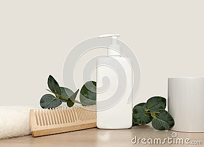 White towel wooden comb green eucalyptus branch. White shampoo. Stock Photo