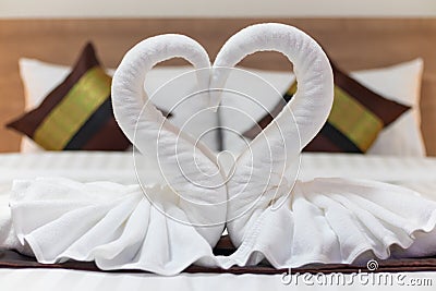 White towels folded into the shape of a pair of swans to symbolize love and fidelity are placed on the suite beds as towels Stock Photo