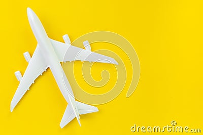 White toy commercial airplane on solid yellow background using as travel and transportation business wallpaper Stock Photo