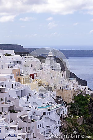 White traditional Greek houses on a hillside on the island of Santorini. Beautiful view of the sea, the ship, the volcano and buil Stock Photo