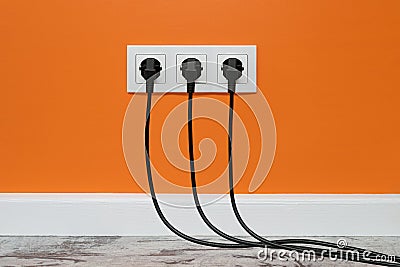 White triple outlet on orange wall Stock Photo