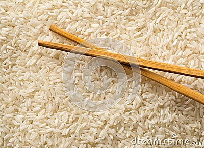 White uncooked, raw long grain rice full frame with chopsticks top view flat lay from above Stock Photo