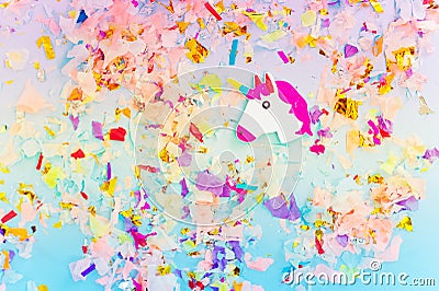 A white unicorn with rainbow horn and confetti top view. Stock Photo