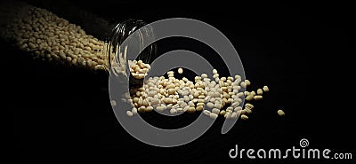 White Urad dal Whole spilled on a Black background Stock Photo