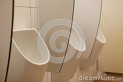 white ceramic urinal in mens bathroom in restaurant toilette Stock Photo