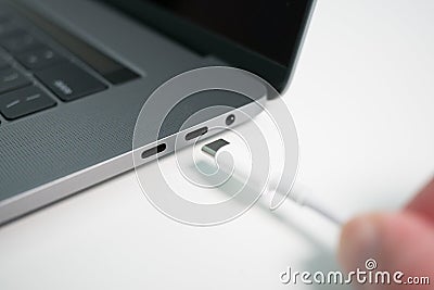 A white USB type C / USB-C cable being plugged into a modern notebook / laptop computer Stock Photo