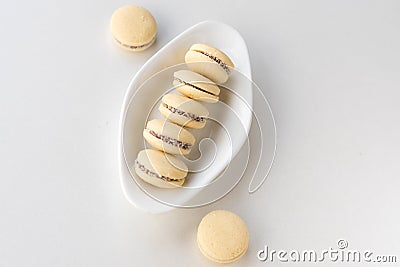 White vanilla macaroons on wooden background. Delicious Argentinian cookies alfajores with cream on plate. Top view. Stock Photo
