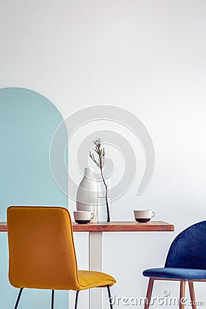 White vase on wooden table with fancy dining room interior with white and blue wall Stock Photo