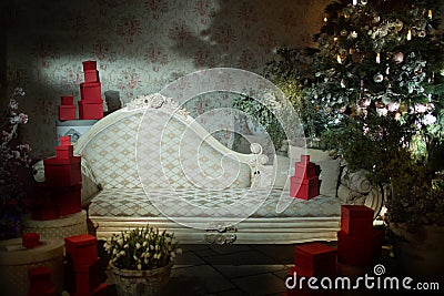 white vintage sofa for background wall with wallpaper and furnished with boxes of gifts and a Christmas tree decorated Stock Photo