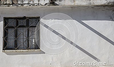 White wall of the house, a window on the wall, two parallel shadows create a rhythm in the photo, Stock Photo