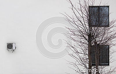 white wall, two windows, tree and air conditioner Stock Photo