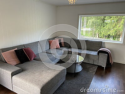 Livingroom with big grey sofa and flatscreen TV white walls Stock Photo