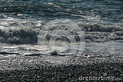 White wave breaking on Sochi Black Sea coast. White spray and foam in the foreground. Emerald blue sea water beyond Stock Photo