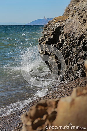 White waves beat against the sea rocks Stock Photo