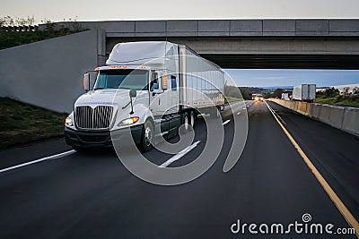 White 18 wheeler semi truck and overpass Stock Photo
