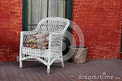 White wicker chair and red brick Stock Photo