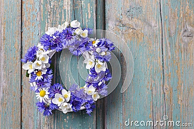 White wicker wreath decorated with cornflowers, chamomiles Stock Photo