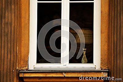 White window in old town building with lamp behind the glass Stock Photo