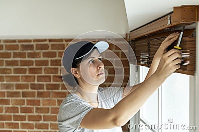 White woman installing window curtain Stock Photo