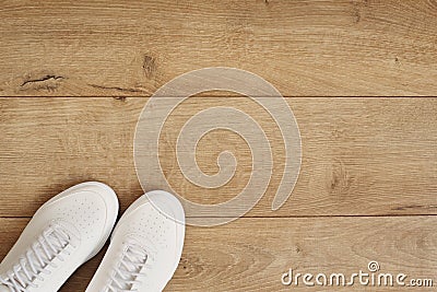 White women sneakers on a wooden background. Flat lay of modern white shoes. Overhead top view photography. Fitness and healthy, s Stock Photo