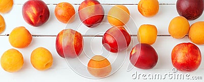 White wooden background with juicy orange apricots and bright fresh red necratins and peaches. Stock Photo