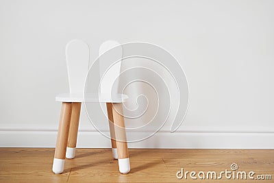 White and wooden child chair with rabbit ears. White wall copy space Stock Photo