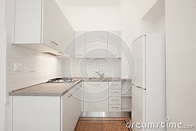 White wooden kitchen with gray stone top in renovated apartment Stock Photo