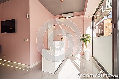 White wooden reception desk in a local beauty salon with pink walls and white marble floors Stock Photo