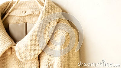 White wool short coat hanging on clothes hanger on white background Stock Photo