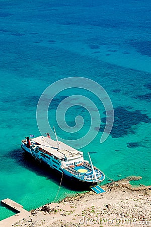 White yacht stands in azure transparent water sea, Balos beach . Aerial view Stock Photo