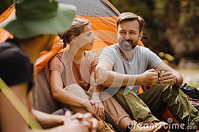 Young travelers resting in tents while hiking in green forest Stock Photo