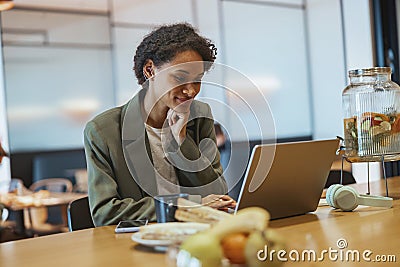 A whitecollar worker sits at a table using a laptop computer Stock Photo