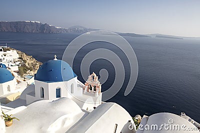 Whitewashed houses and blue dome church by the Aegean sea, Santoriniin Oia, Santorini, Greece. Famous blue domes in Oia village, Stock Photo