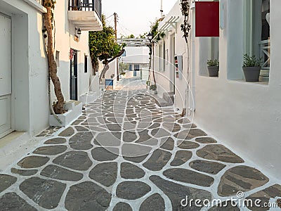 Whitewashed houses empty cobblestone alley at Naousa village, Paros island, Greece Stock Photo