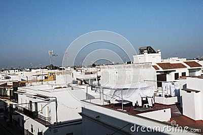 Whitewashed houses on white aerial view of terraces, roofs, clothes hanging with blue sky background Stock Photo