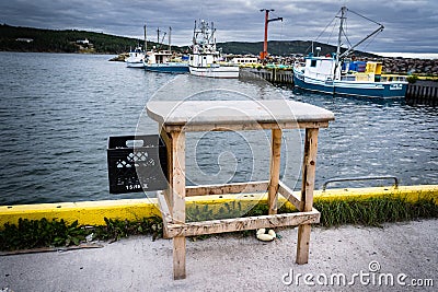 A fish cleaning table overlooking a marina with fishing boats along the Canadian East coast. Editorial Stock Photo