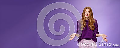 Who cares chill I not know. Portrait of clueless and unbothered cute redhead female in purple sweater smirking in sorry Stock Photo
