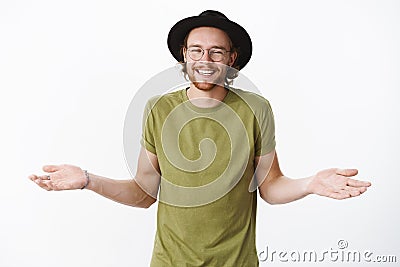 Who cares just chill. Studio shot of unbothered and relaxed handsome party hipster guy with beard in hat and glasses Stock Photo
