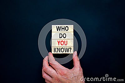 Who do you know symbol. Concept words Who do you know on wooden blocks. Businessman hand. Beautiful black table, black background Stock Photo