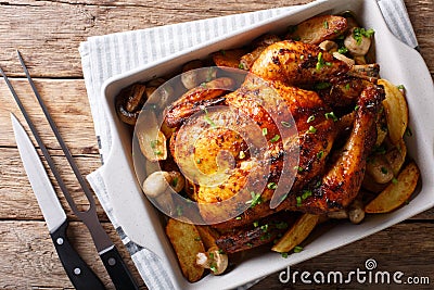 Whole baked chicken with mushrooms and potatoes close-up in a ba Stock Photo