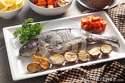 Whole Baked Rainbow Trout on a Table Set for Dinner Stock Photo