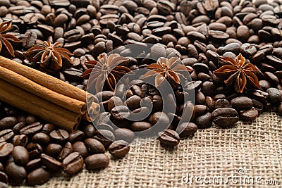 Whole bean coffee with star aniseas and cinnamon sticks on light burlap with space for text Stock Photo