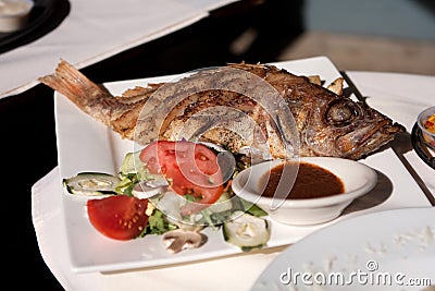 Whole cooked fish and salad Stock Photo