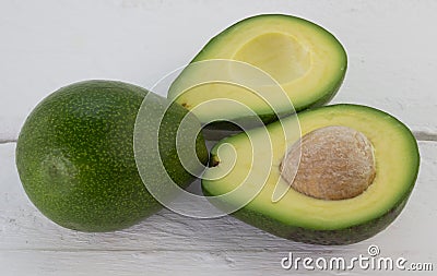 Whole and cut avocados on rustic white wood Stock Photo